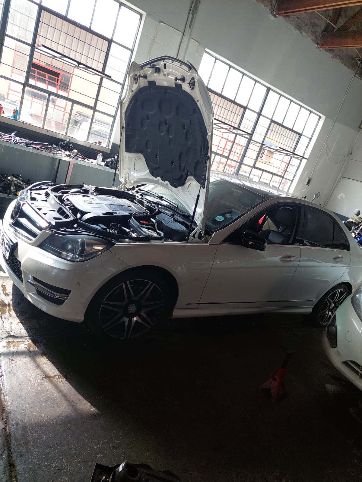White Mercedes-Benz in the workshop with bonnet raised