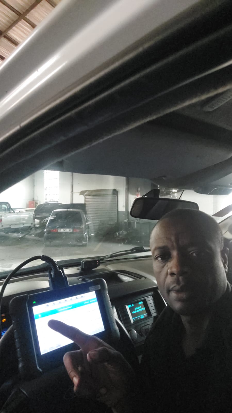 Technician running a diagnostic scan inside a vehicle