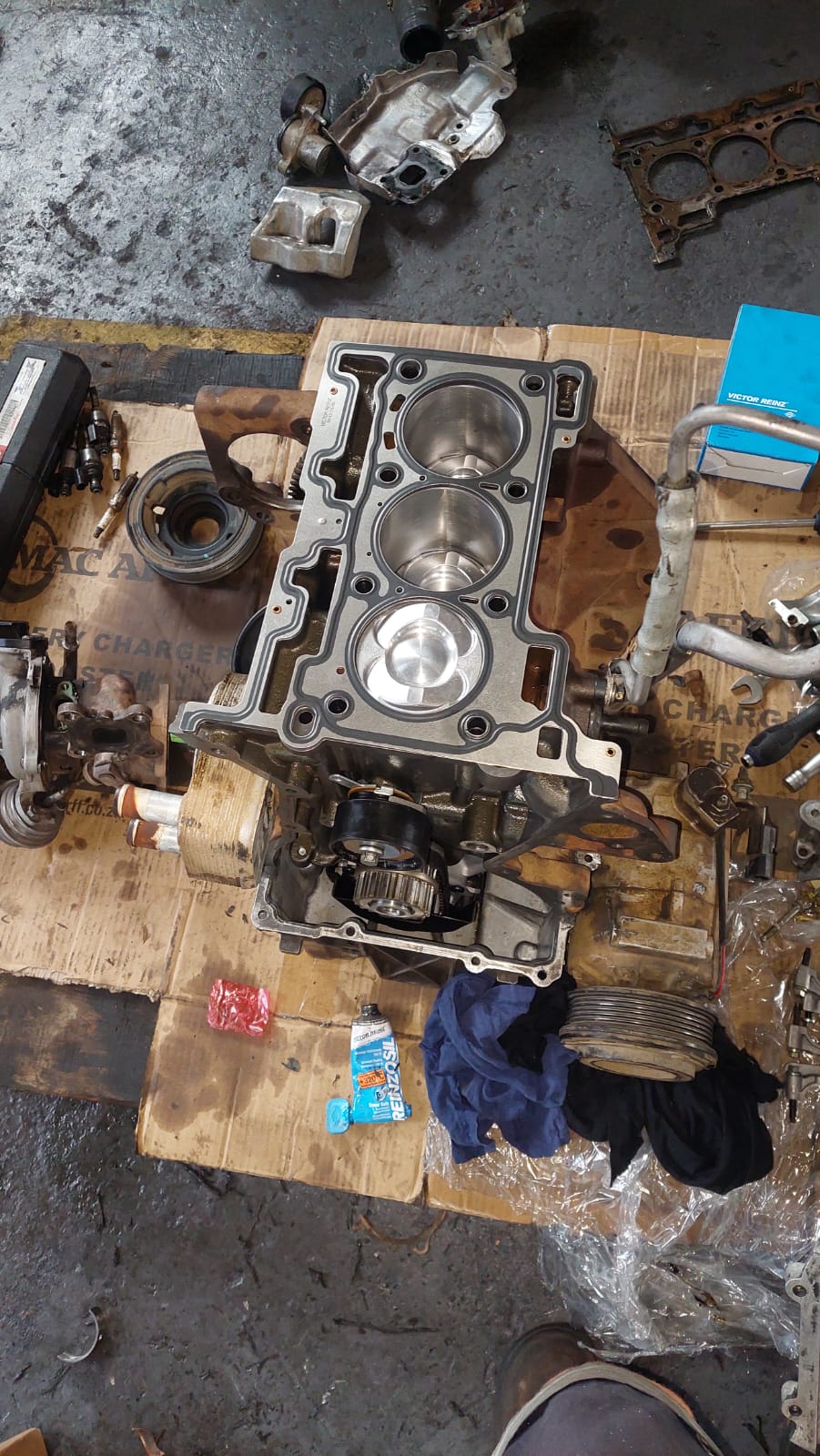 Engine block with new pistons and gasket during a rebuild