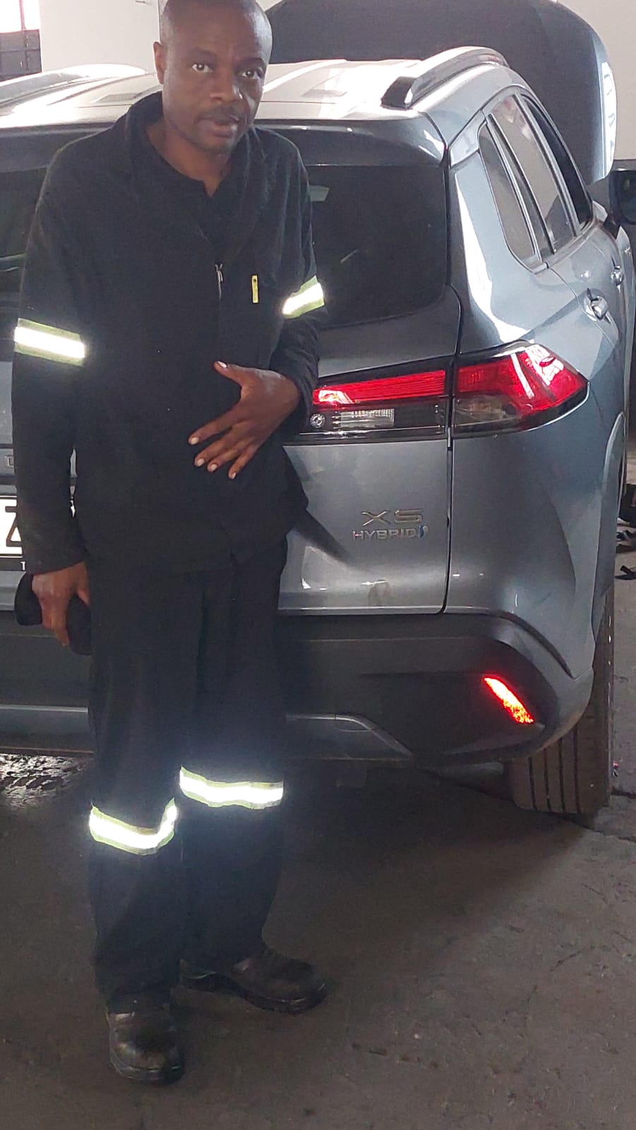 Technician alongside a Toyota Corolla Cross Hybrid
